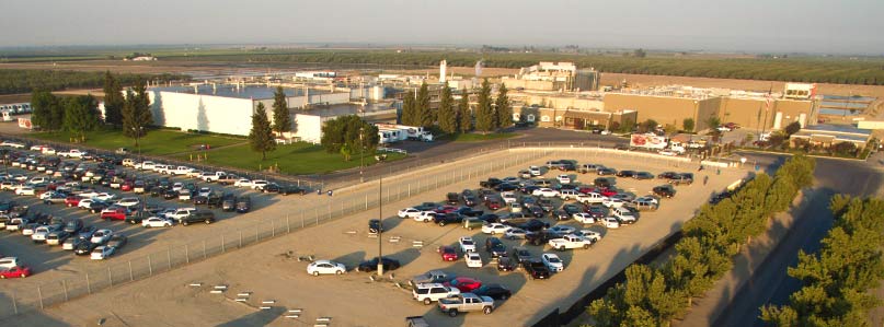 Aerial of Harris Ranch Beef Company: buildings, full parking lot, trees