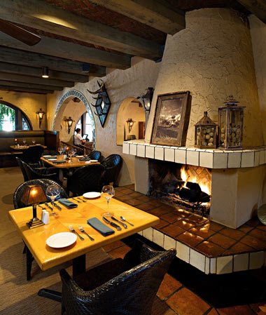 table set at Harris Ranch Restaurant. Lit fireplace to right of table